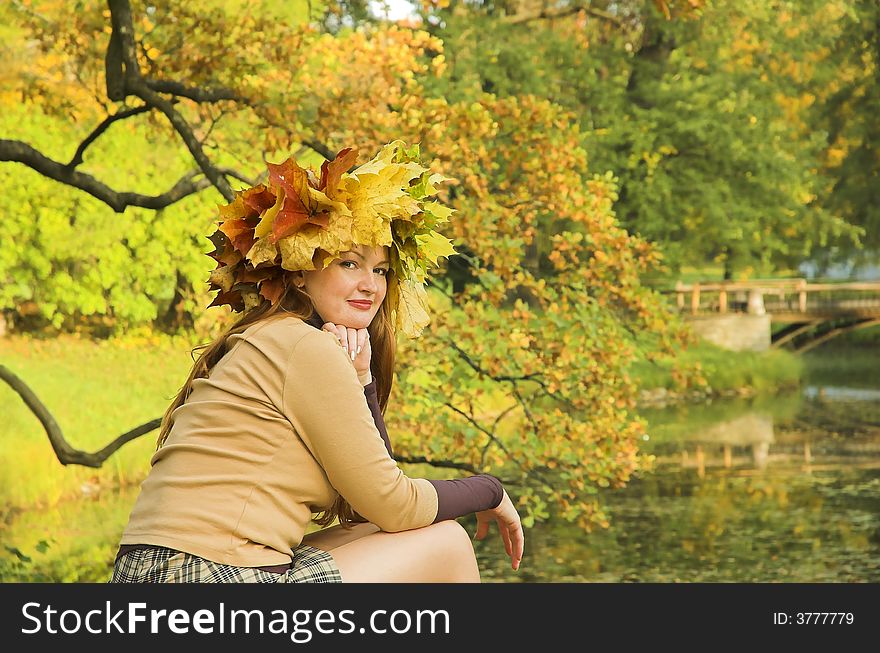 Portrait of the girl in a wreath from maple leaves