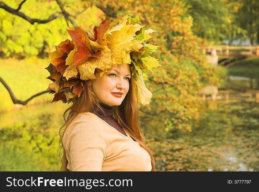 Portrait of the girl in a wreath from maple leaves