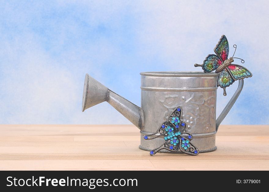 Metal Watering Can on Blue Sky Background