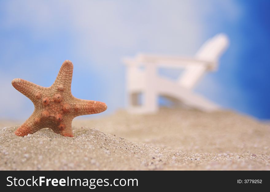 Starfish on Sand With Chair and Blue Sky Background, Shallow DOF. Starfish on Sand With Chair and Blue Sky Background, Shallow DOF