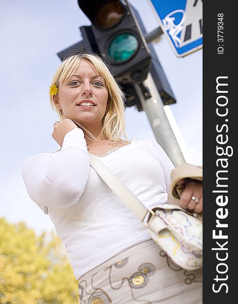 Blond girl with a yellow flower standing at a traffic light. Blond girl with a yellow flower standing at a traffic light.