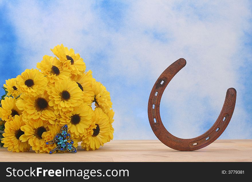 Yellow Flowers and Rusty Horseshoe on Blue and White Textured Background. Yellow Flowers and Rusty Horseshoe on Blue and White Textured Background