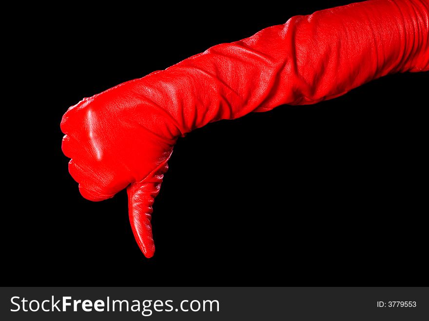 Hand in red glove on the black background showing that something is bad. Hand in red glove on the black background showing that something is bad