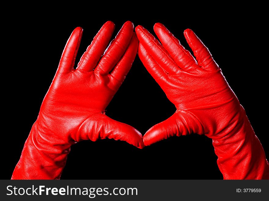 Hands in red gloves on the black background showing some signs. Hands in red gloves on the black background showing some signs