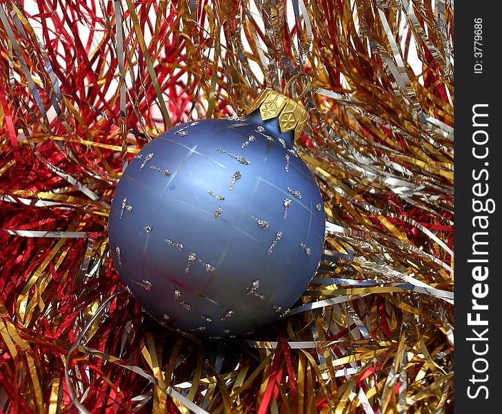 Blue Christmas ball on multi-coloured shiny background