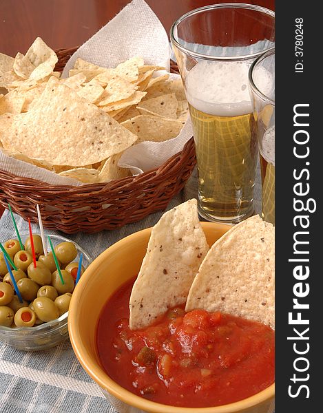 Table top with beer, chips, olives and salsa. Table top with beer, chips, olives and salsa