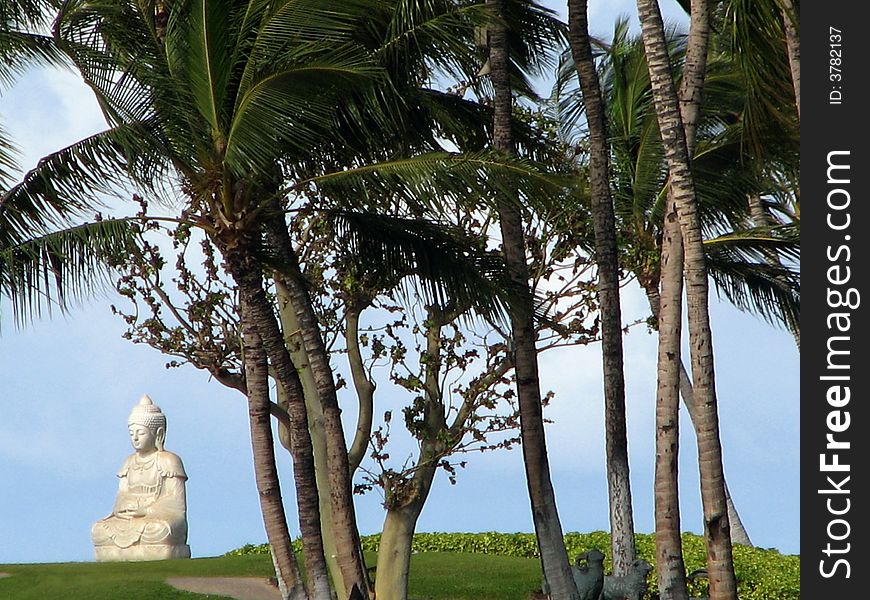 A white Buddha Statue on a tropical island.