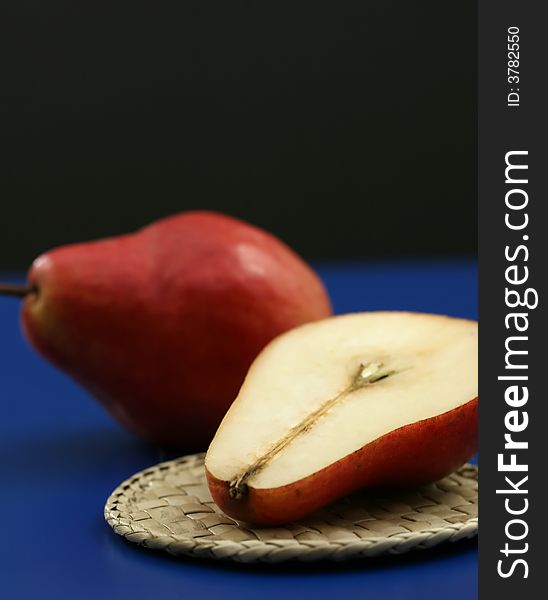 Fresh red organic pears with a blue and black background. Fresh red organic pears with a blue and black background