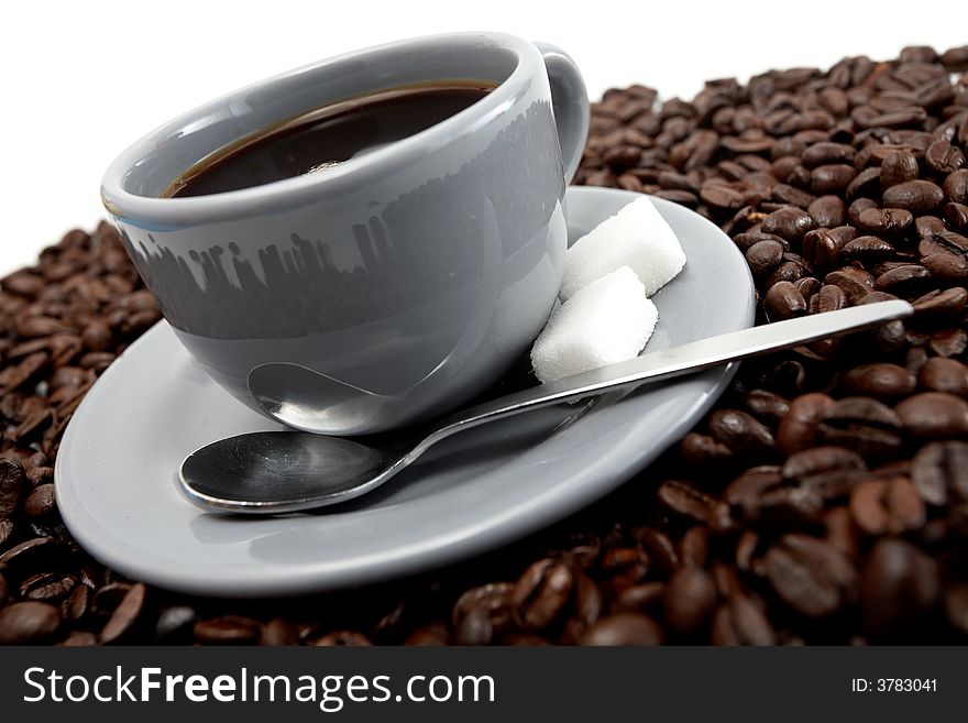 Grey cup of coffee with beans over white background