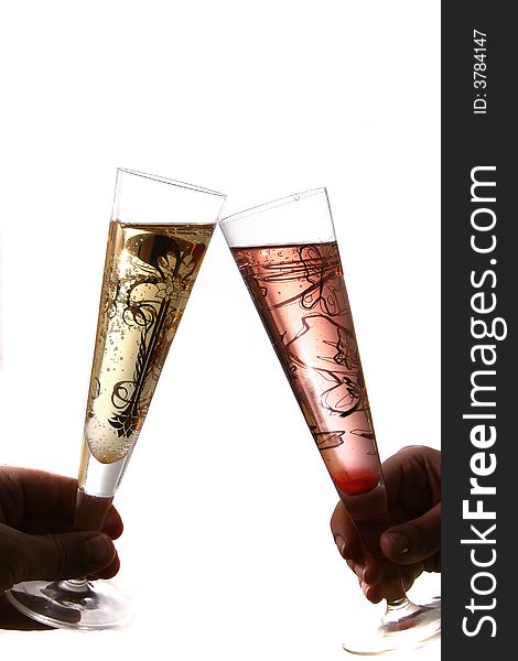 Pair of red and gold champagne flutes making a with bubbles held by hand. Isolated on white space (for text). Pair of red and gold champagne flutes making a with bubbles held by hand. Isolated on white space (for text).