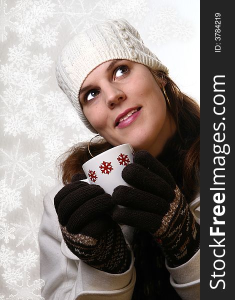 A young woman holding a cup of tea in winterclothes with snowflakes. Isolated over white space (for text). A young woman holding a cup of tea in winterclothes with snowflakes. Isolated over white space (for text).