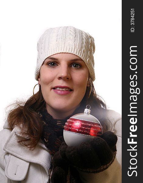 A young woman is holding christmas decoration. She is happy with winter gear on. Isolated over white with space for text. A young woman is holding christmas decoration. She is happy with winter gear on. Isolated over white with space for text.