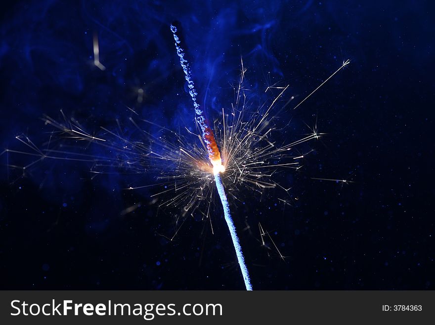 Image of burning sparkler and blue smoke