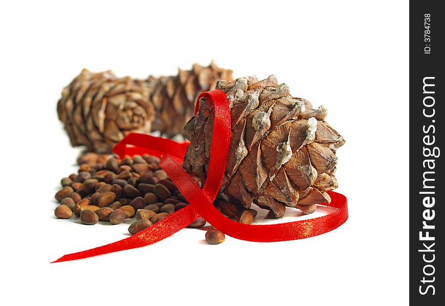 Nuts, cones and red ribbon isolated on a white background. Nuts, cones and red ribbon isolated on a white background