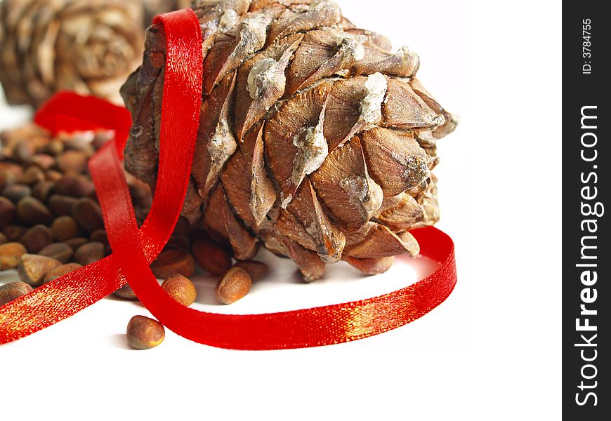 Nuts, cones and red ribbon on a white background. Nuts, cones and red ribbon on a white background