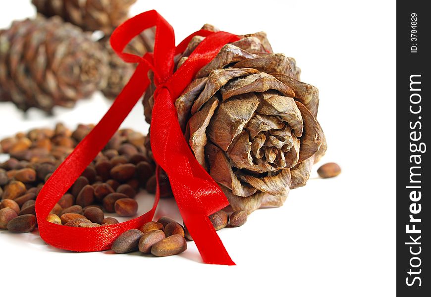 Nuts, cones and red ribbon on a white background. Nuts, cones and red ribbon on a white background