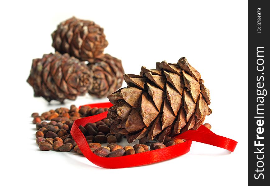 New year still life with nuts, cones and red ribbon isolated on a white background. New year still life with nuts, cones and red ribbon isolated on a white background