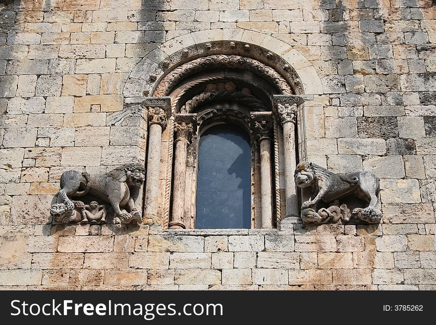 Window of a chuch in the medieval town of Besalu, Spain. There are two stone lions on each side. Window of a chuch in the medieval town of Besalu, Spain. There are two stone lions on each side.