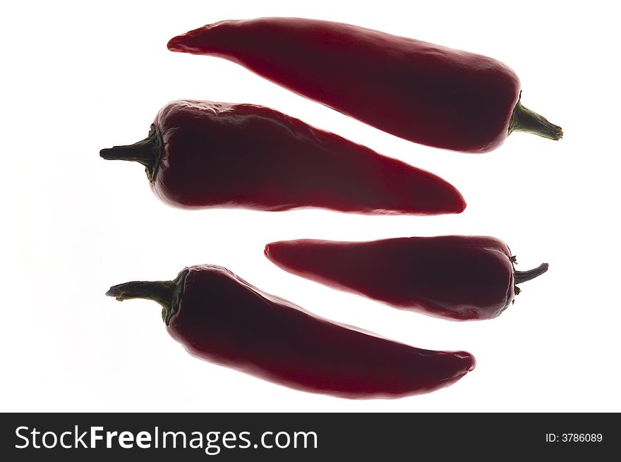 Backlit Red chilli peppers, isolated on a white background. Lit from underneath and shot overhead.