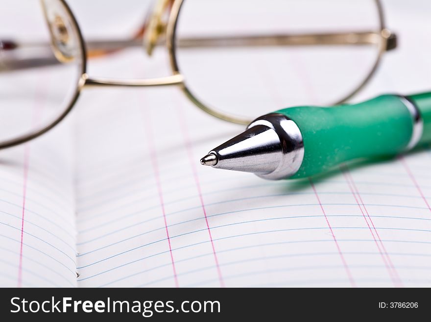 Pen and glasses on the notebook. Pen and glasses on the notebook.