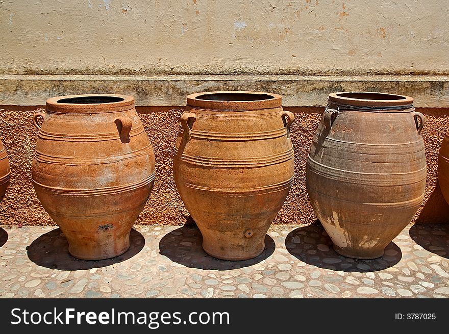 Traditional greek jugs beside the church wall