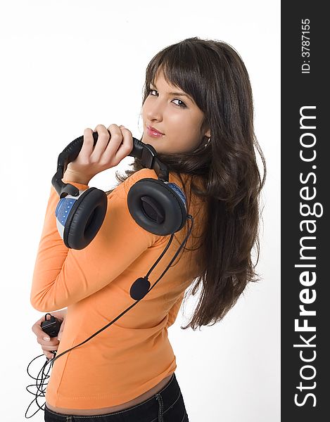 Beautiful brunette girl with headphones listening music and playing. Nice orange shirt.
