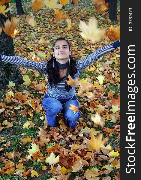 A girl throwing autumn leaves. A girl throwing autumn leaves