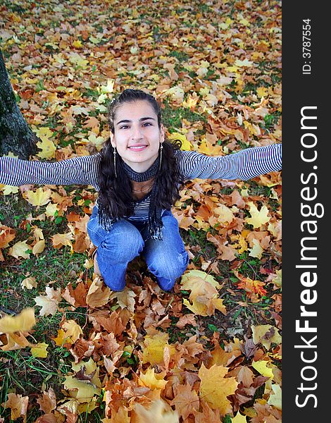 A girl sitting in the autumn leaves. A girl sitting in the autumn leaves