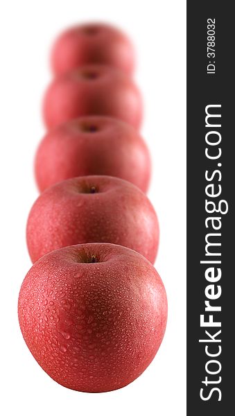 A row of red apples sprinkled with water