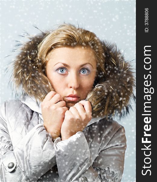 Young women in fur hood with worried expression on face in snow. Young women in fur hood with worried expression on face in snow