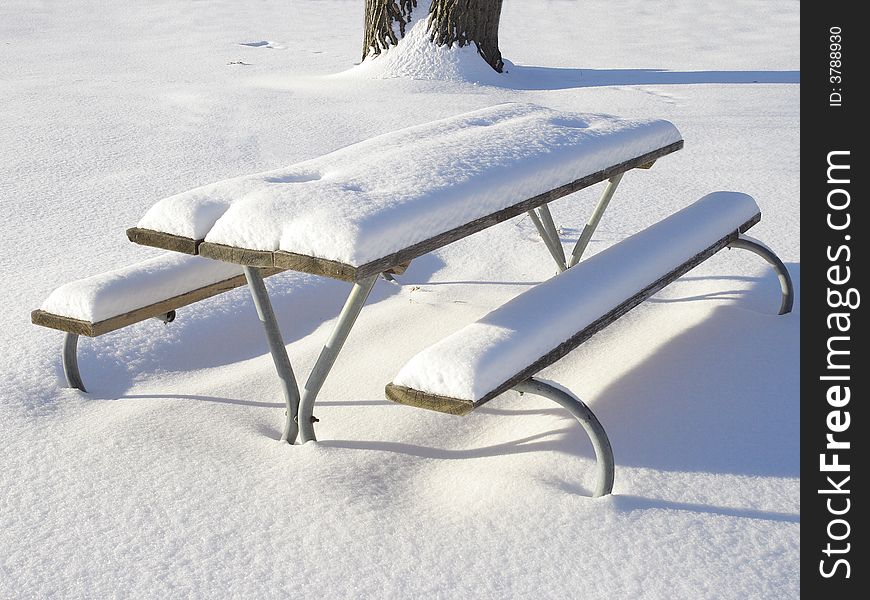 Winter in the park, fresh snow on the picnic table