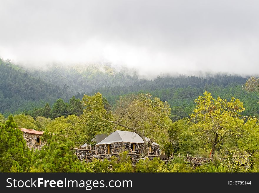 Rustic house in the middle of the forest, near the clouds limit.