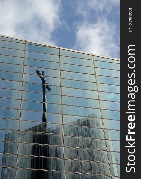 Christian cross reflected in glass panels of building. Christian cross reflected in glass panels of building