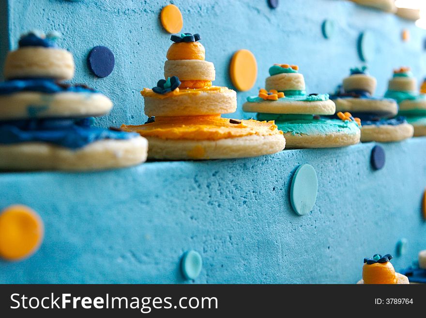 An image of up close decorated cookies on top of a gourmet cake
