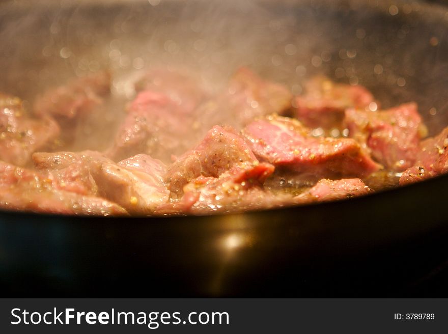 Image of beef tenderloin pieces grilling in a frying pan