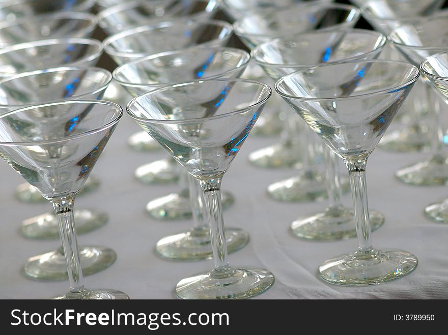 An image of rows of martini glasses on a white cloth