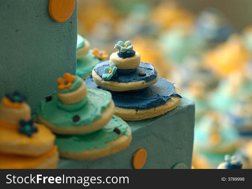 An image of decorated cookies on top of a beautiful wedding cake. An image of decorated cookies on top of a beautiful wedding cake