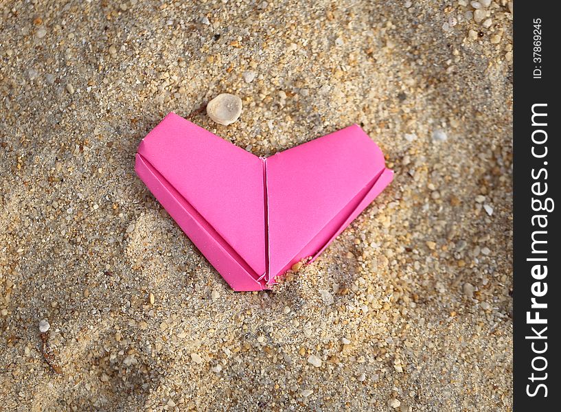 Festive pink paper heart on the beach. Festive pink paper heart on the beach