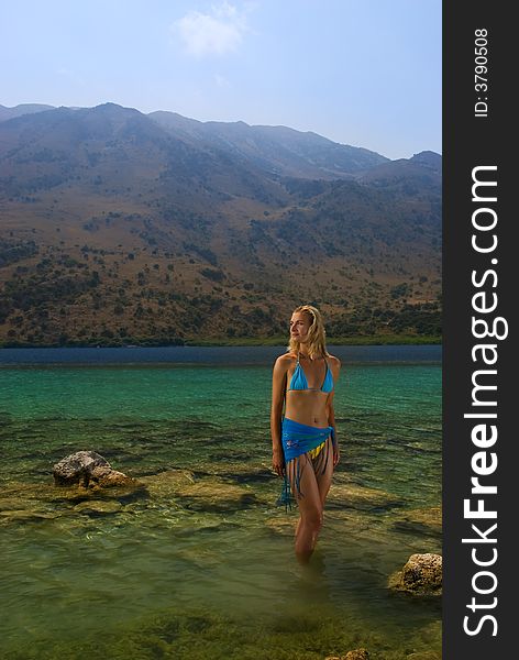 Beautiful blond girl standing in crystal clear water