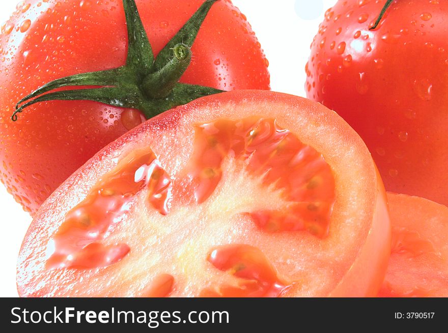 Ripe juicy tomatoes isolated on white; wet. Ripe juicy tomatoes isolated on white; wet