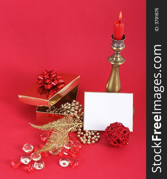 Christmas candle with flame. A white card in front. Red background. Christmas candle with flame. A white card in front. Red background.