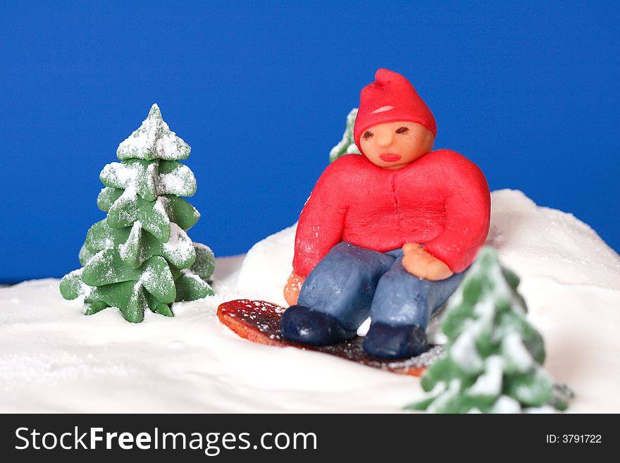 Detail of birthday cake -marzipan figure - boy on the snowboard and trees