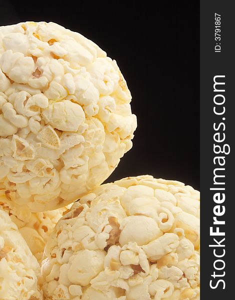 Closeup view of several popcorn balls isolated on black.