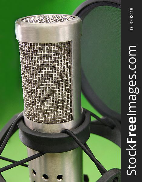 Studio silver steel microphone in green room. Studio silver steel microphone in green room