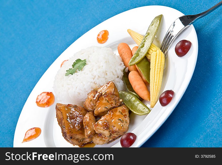 Colorful Tai sticky chicken dish taken over a blue background.