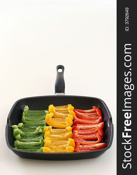 Colorful rows of green, yellow and red capsicum strips prepared for cooking on a pan. Colorful rows of green, yellow and red capsicum strips prepared for cooking on a pan