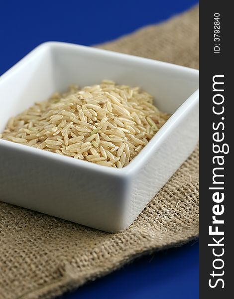 Healthy brown rice on a blue background