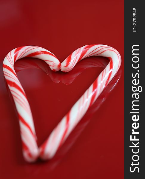 A christmas candy cane heart on a red background. A christmas candy cane heart on a red background