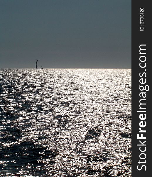 Sea of light with sailing boat