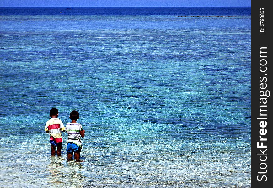 Two boys fishing on Mabul island in Borneo. Two boys fishing on Mabul island in Borneo.